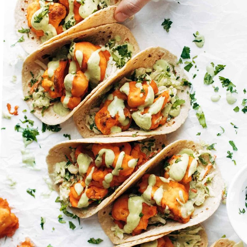 Buffalo Cauliflower Tacos on table in a row.