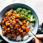 Cashew chicken in a bowl with rice and broccoli.