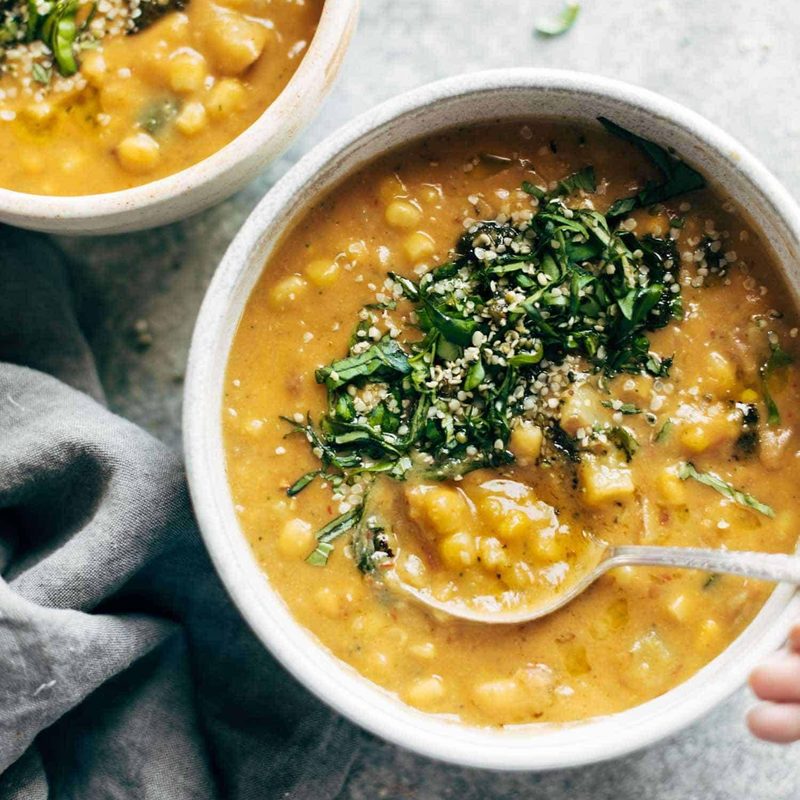 Corn chowder in a bowl with herbs on top.