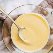 Honey mustard sauce in a bowl with a spoon.