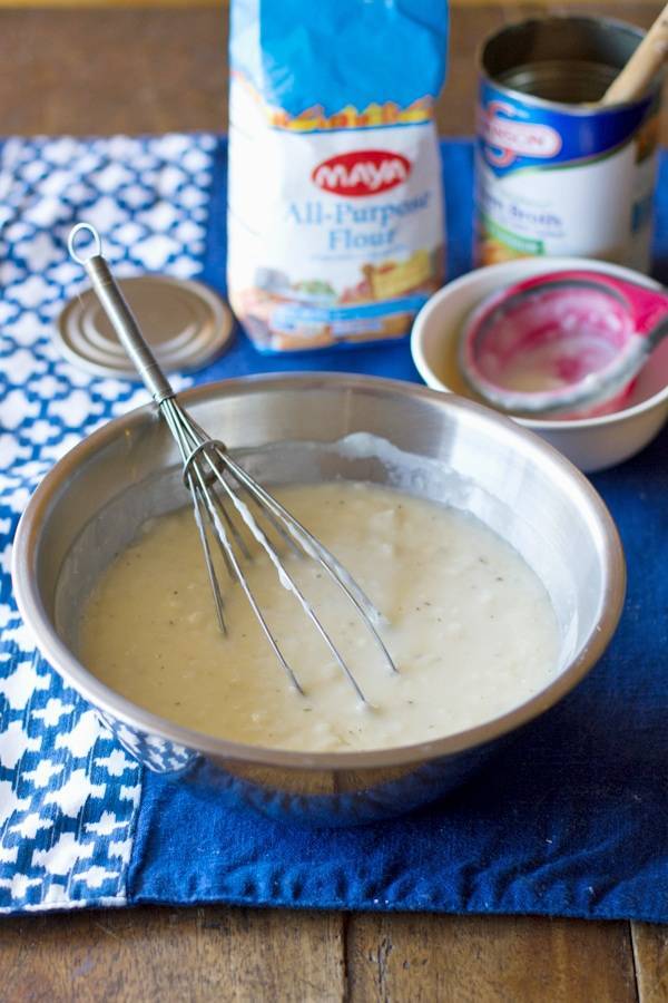 This is a super easy recipe for making your own homemade cream of chicken soup. Just four ingredients and sooo delicious! | pinchofyum.com Whisk sitting in a bowl with ingredients for cream of chicken soup.
