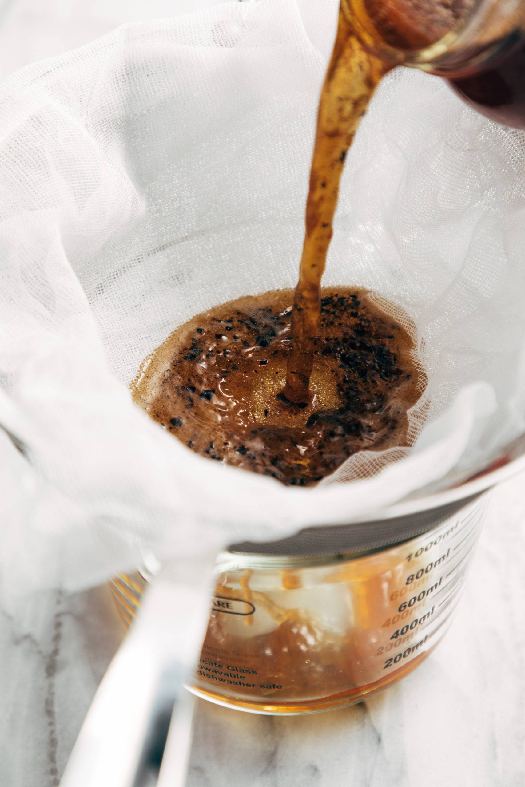 Cold brew being filtered into jar