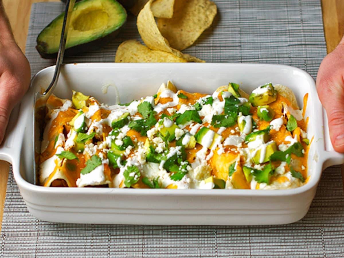 Chicken enchiladas in a white baking dish.