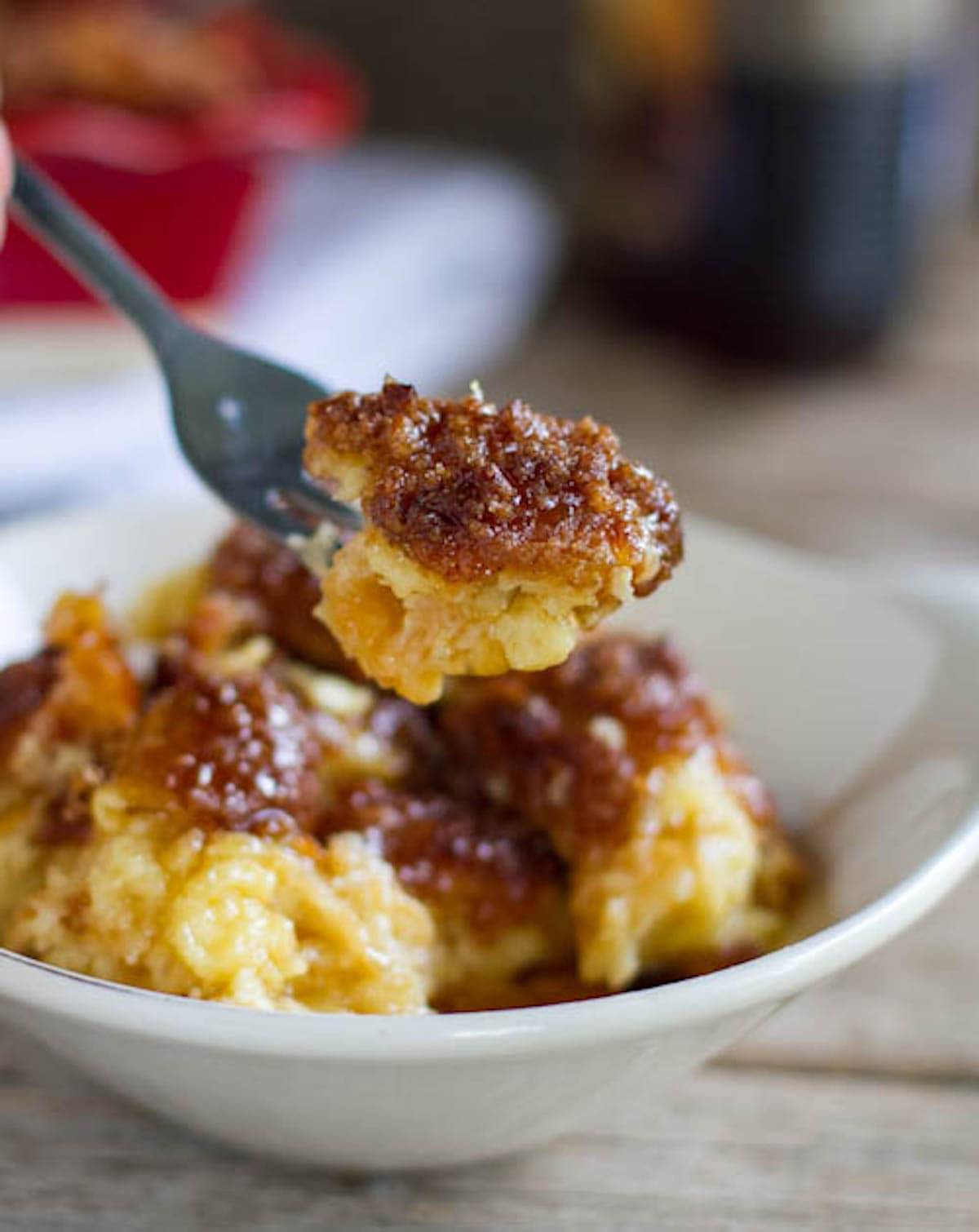 Cinnamon croissant French toast in a bowl and on a spoon.