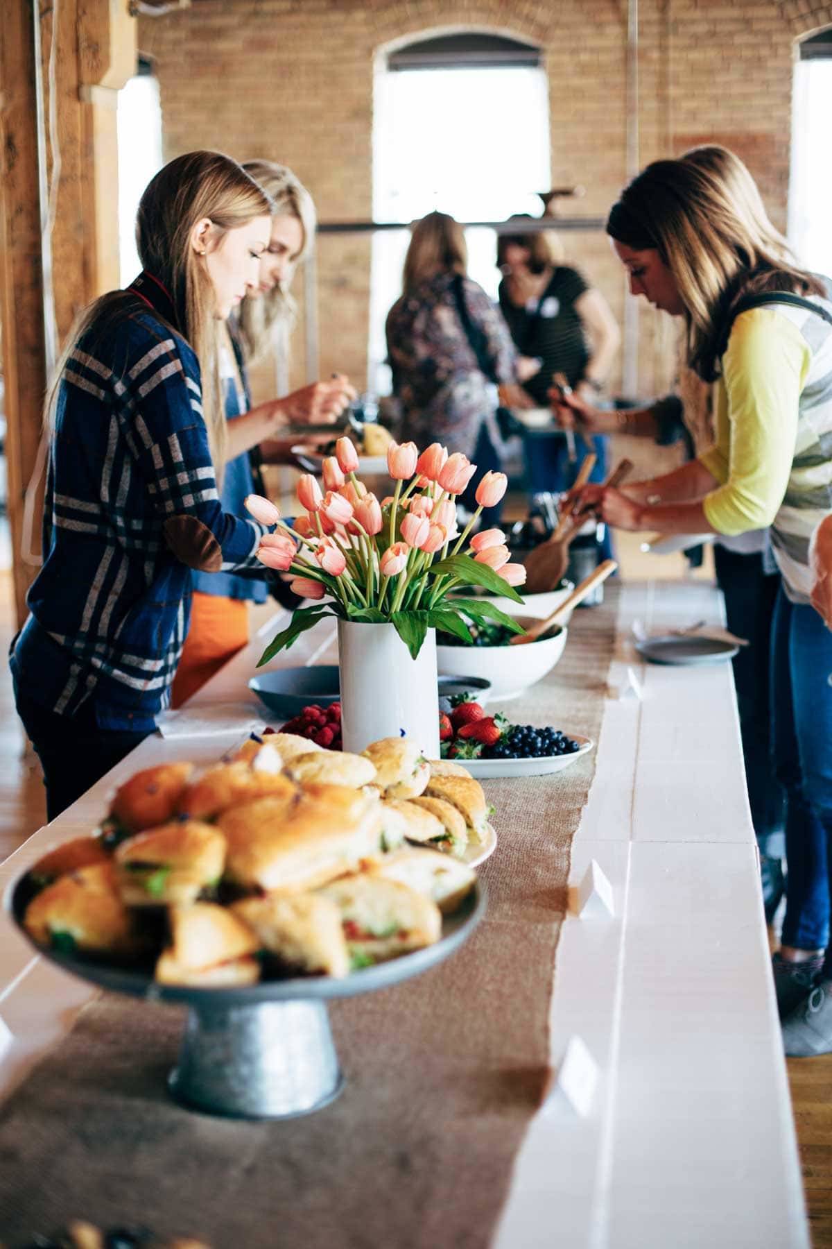 Women in a food buffet line.